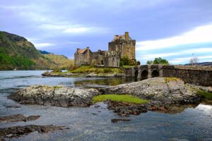 Eilean Donan Castle on rocky islet with arched stone bridge and calm loch
