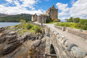 Eilean Donan Castle beside rocky loch and stone bridge