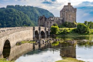 Eilean Donan Castle by stone bridge and loch