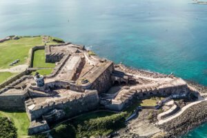 Aerial view of El Morro fortress on rocky coastline with turquoise Atlantic waters