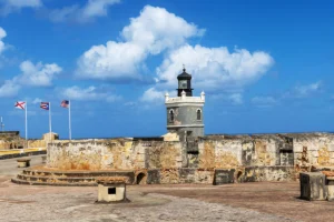 View of El Morro lighthouse and fort walls under blue sky