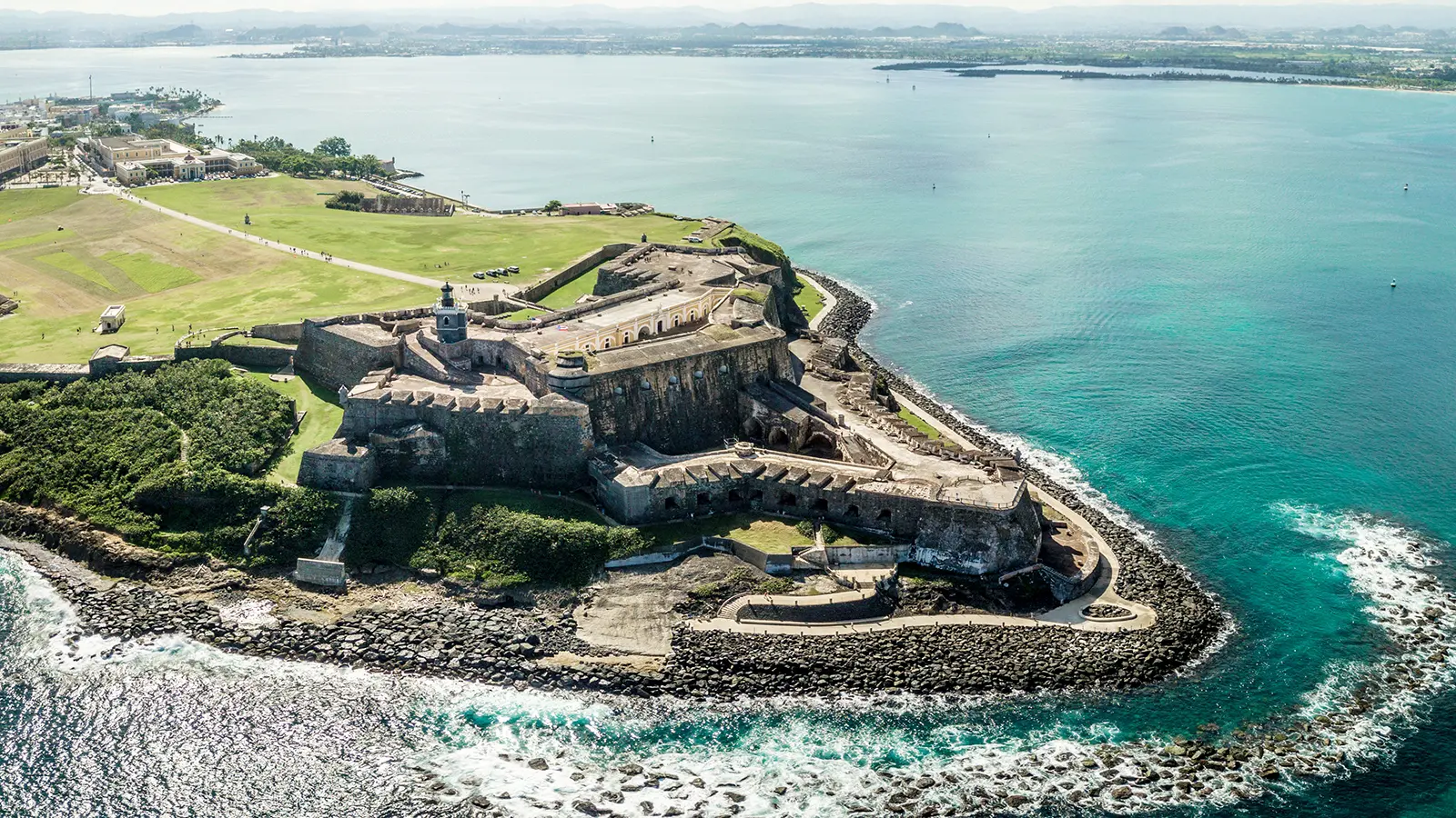 Aerial view of El Morro fortress on rocky headland with turquoise ocean
