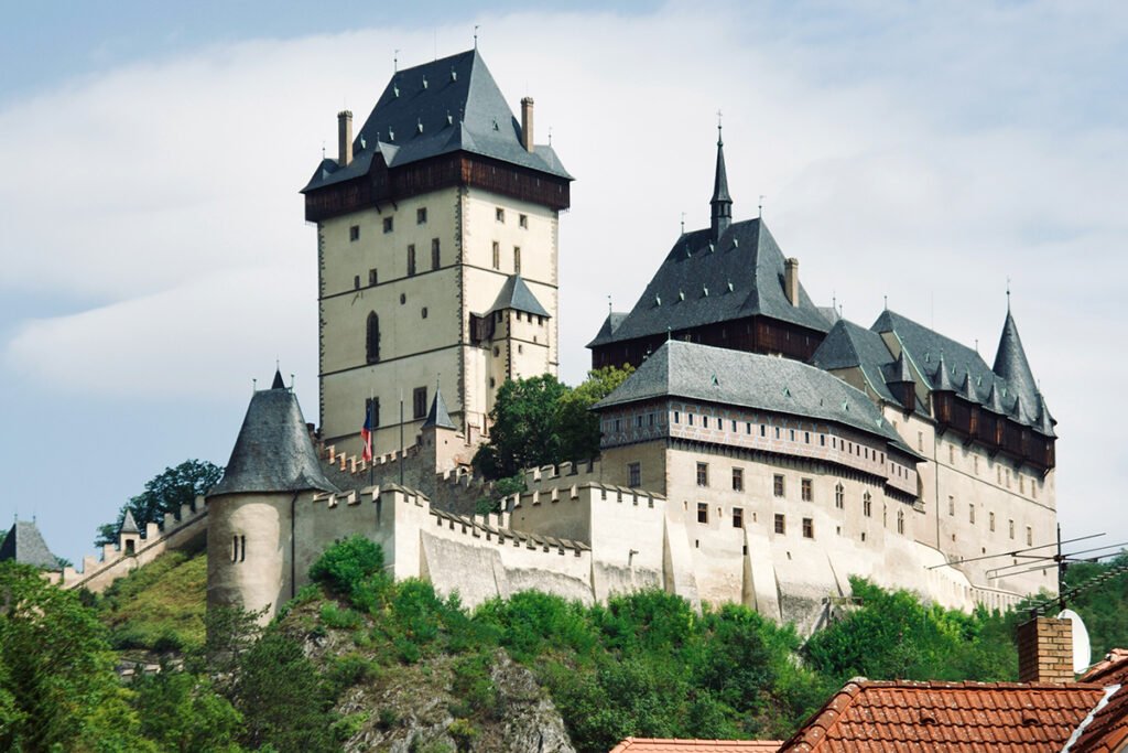 Exterior view of Karlštejn Castle perched above forested valley