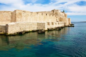 Maniace Castle seaside fortress with blue waters and clear sky