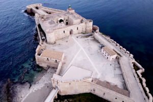 Aerial view of Maniace Castle on rocky sea outcrop