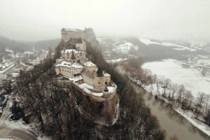 Orava Castle perched on snowy cliff above river