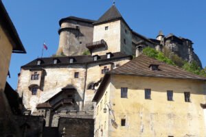 Orava Castle towering over stone courtyards under blue sky