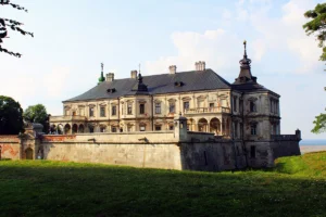 Historic Pidhirtsi Castle stands on a grassy hilltop under a bright sky in western Ukraine.