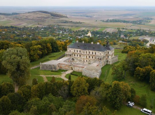 Aerial view of Pidhirtsi Castle on wooded hill and surrounding farmland