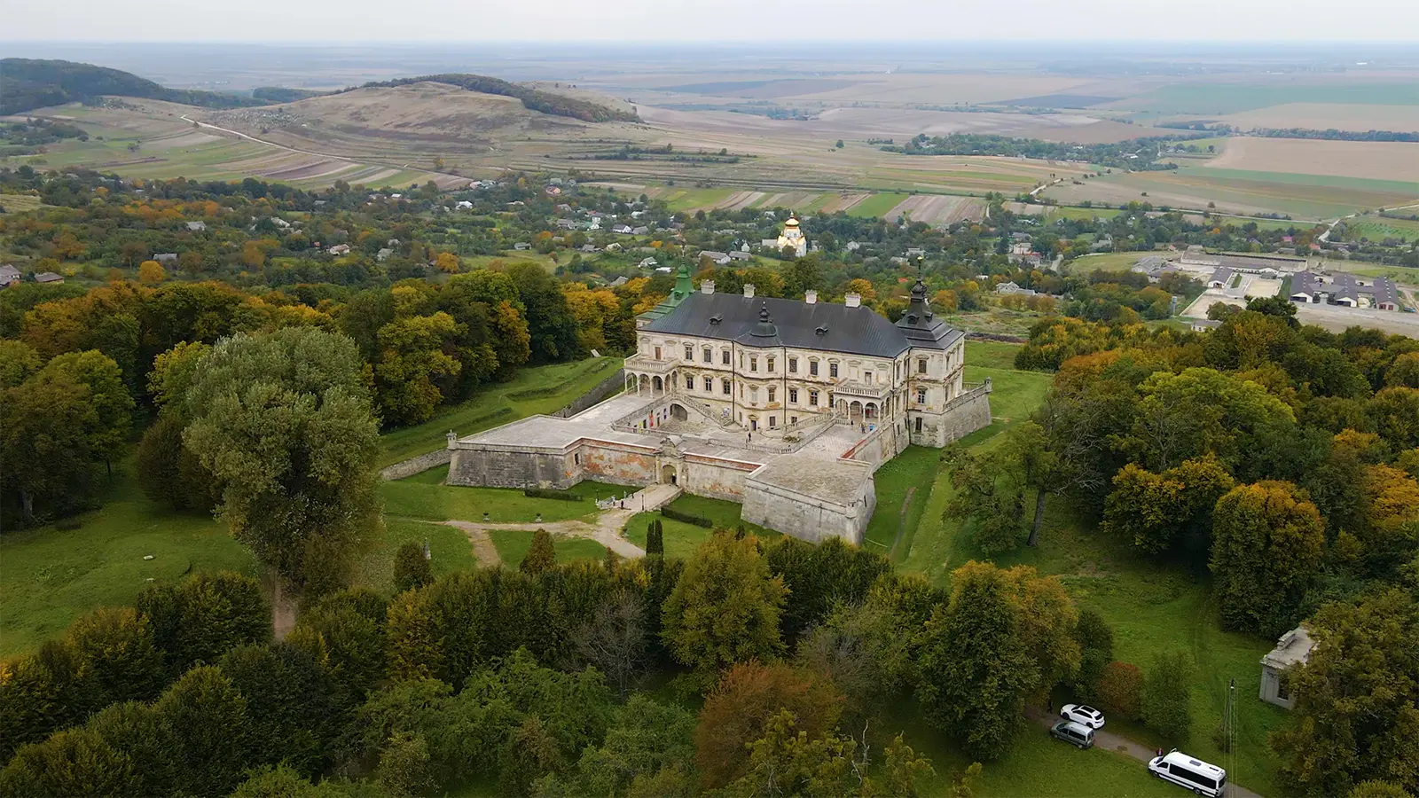 Aerial view of Pidhirtsi Castle on wooded hill and surrounding farmland
