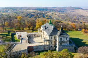 Aerial view of Pidhirtsi Castle amid autumn trees and rolling hills