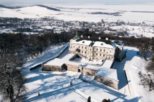 Aerial view of Pidhirtsi Castle blanketed in snow with surrounding landscape