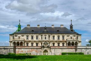Pidhirtsi Castle front view with lawn and cloudy sky