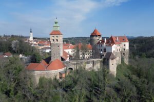 Aerial view of Schlaining Castle on hillside with red roofs and towers