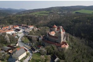 Aerial view of Schlaining Castle on wooded hill above village