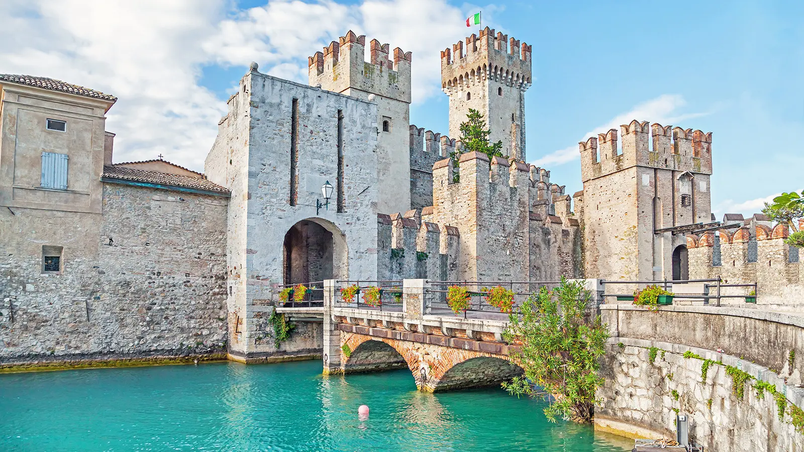 Sirmione Castle stone towers and bridge over turquoise Lake Garda