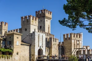 Sirmione Castle stone towers and entrance bridge on bright day