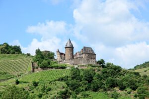 Stahleck Castle perched above terraced vineyards on a sunny day