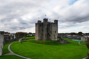 Trim Castle central tower with green lawn and cloudy sky