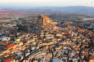Aerial view of Uçhisar Castle above Cappadocia village at sunrise