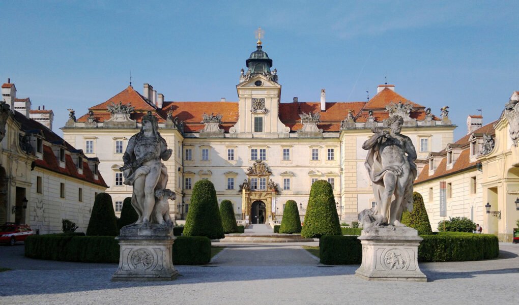 Front facade of Valtice Castle with statues and formal garden