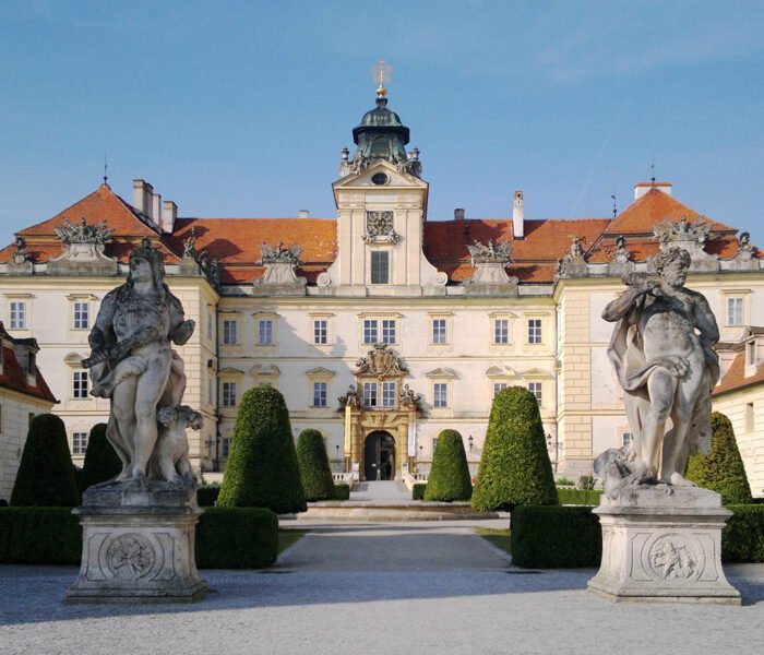 Front facade of Valtice Castle with statues and formal garden