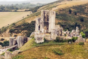 Aerial view of Corfe Castle ruins on grassy Dorset hills