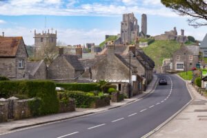 Corfe Castle ruins above stone village and winding road