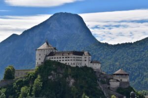 Kufstein Fortress perched on rocky hill with surrounding forest and mountain backdrop