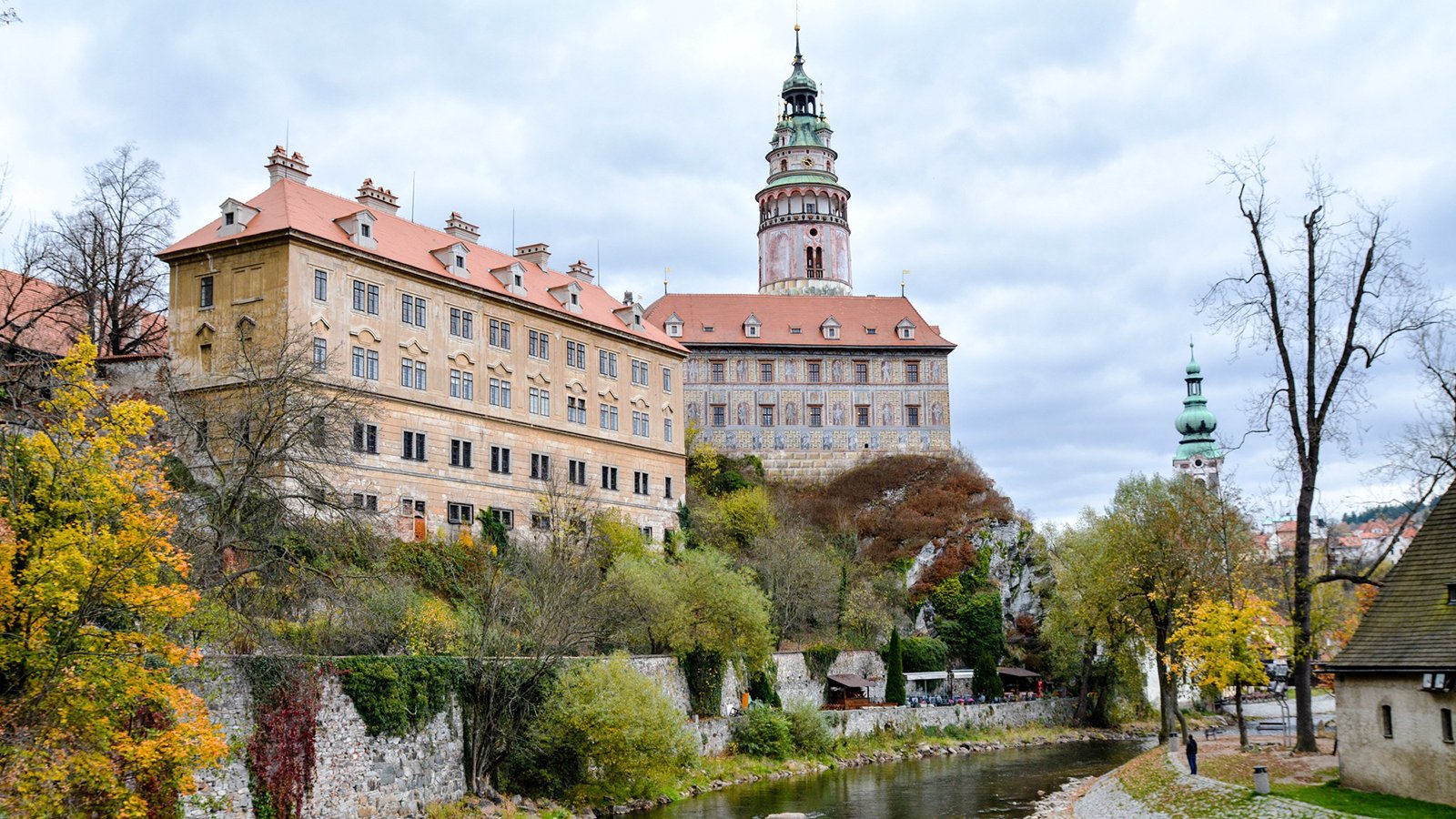 Cesky Krumlov Castle perched above river with autumn trees and tower