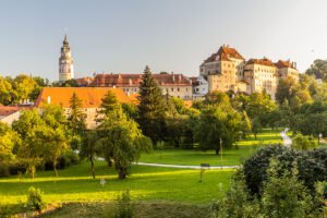 Cesky Krumlov Castle from park, tower and red roofs at sunset