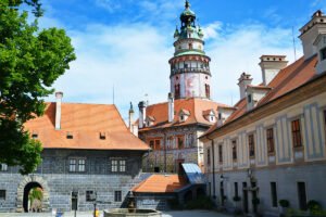 Cesky Krumlov Castle tower rising above red roofs and courtyard