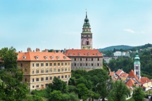 Cesky Krumlov Castle tower above red-roofed town and lush river valley