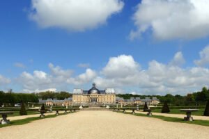 Front view of Château de Vaux-le-Vicomte with gardens under blue sky