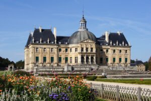 Front façade and gardens of Château de Vaux-le-Vicomte under blue sky
