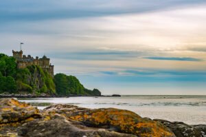 Culzean Castle atop rocky coastal cliffs at sunset