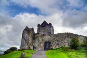 Dunguaire Castle beside green lawn under cloudy sky