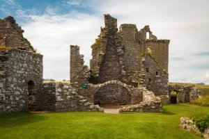 Dunnottar Castle stone ruins and green lawn under cloudy sky