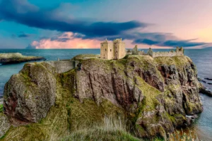 Dunnottar Castle perched on rugged coastal cliffs at sunset