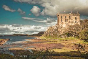 Dunvegan Castle perched on rocky promontory overlooking tidal bay