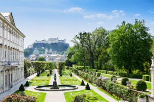 Fortress Hohensalzburg above Mirabell Gardens and fountain on sunny day