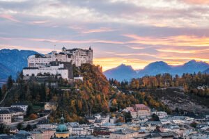 Fortress Hohensalzburg above Salzburg at colorful sunset with mountains