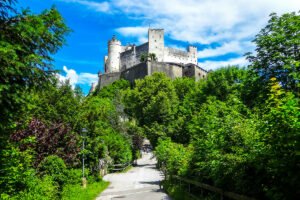 Fortress Hohensalzburg above green trees and path