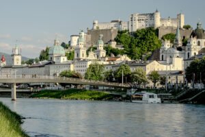 Fortress Hohensalzburg atop green hill above the Salzach river