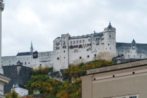 Fortress Hohensalzburg sitting atop a rocky hill above Salzburg rooftops