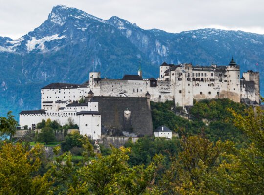 Fortress Hohensalzburg on hill with alpine backdrop