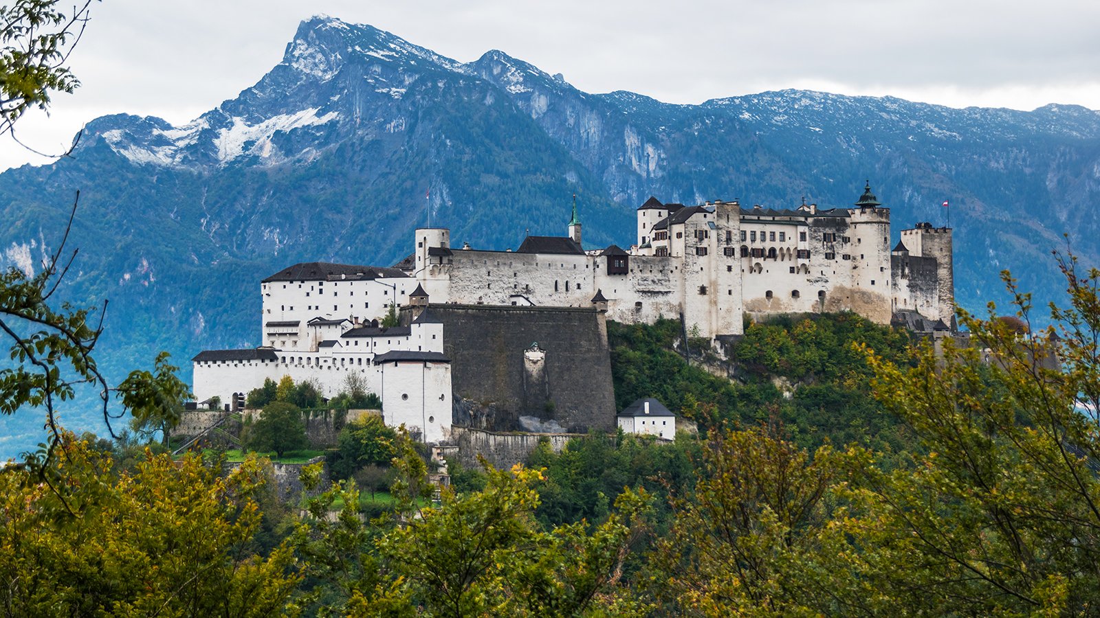 Fortress Hohensalzburg on hill with alpine backdrop