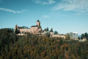 Haut-Koenigsbourg Castle on wooded hill under blue sky
