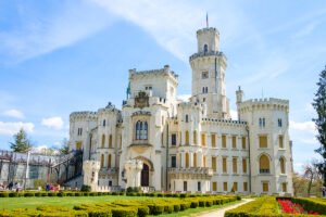 Hluboka Castle façade with towers, gardens and blue sky