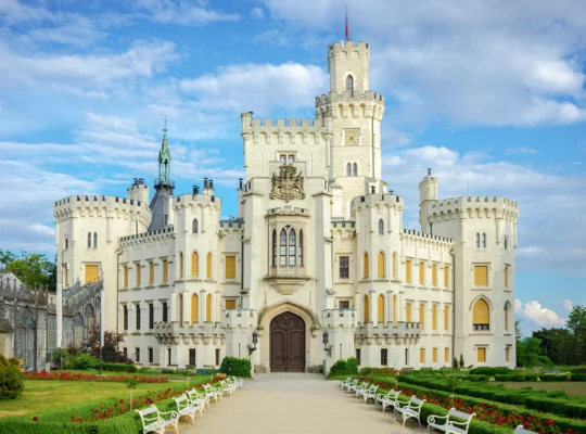 Fachada do Castelo de Hluboka com jardins e céu azul